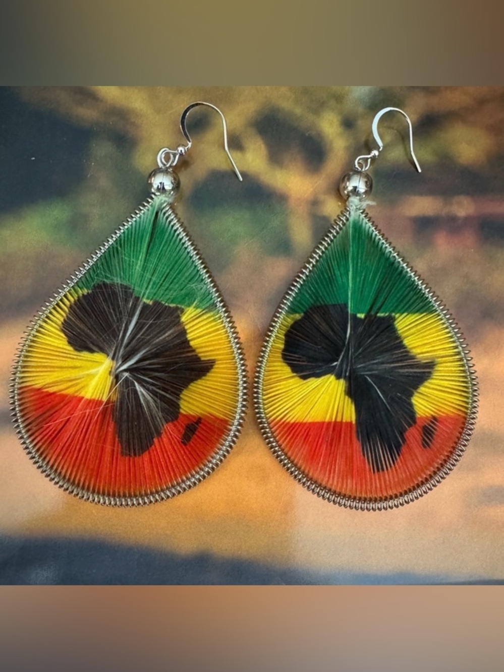 Woven string earrings with African continent design and flag colors